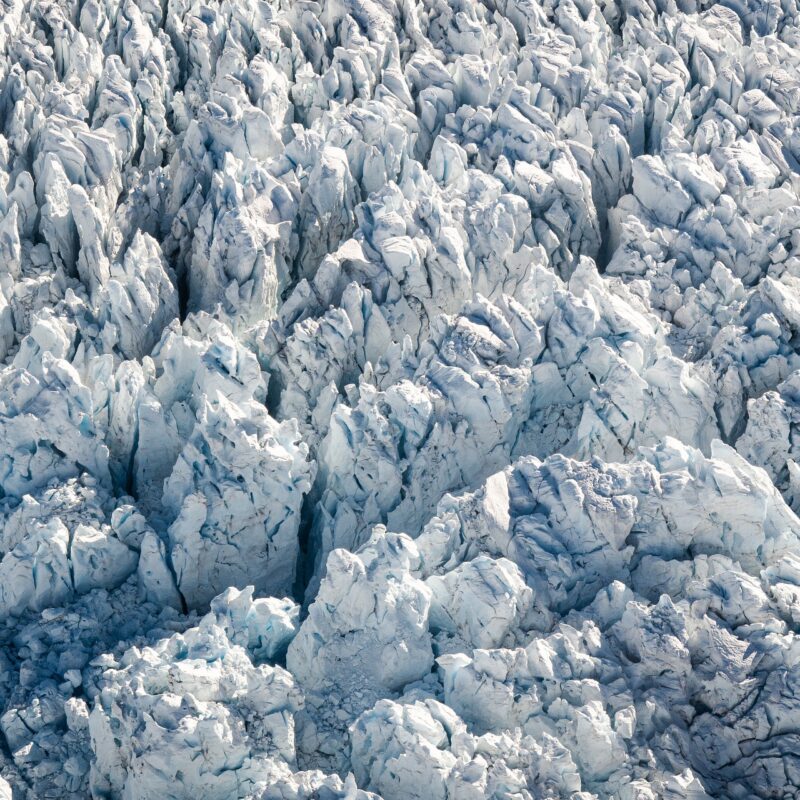 An aerial shot of a glacier with shark spiky ice formations